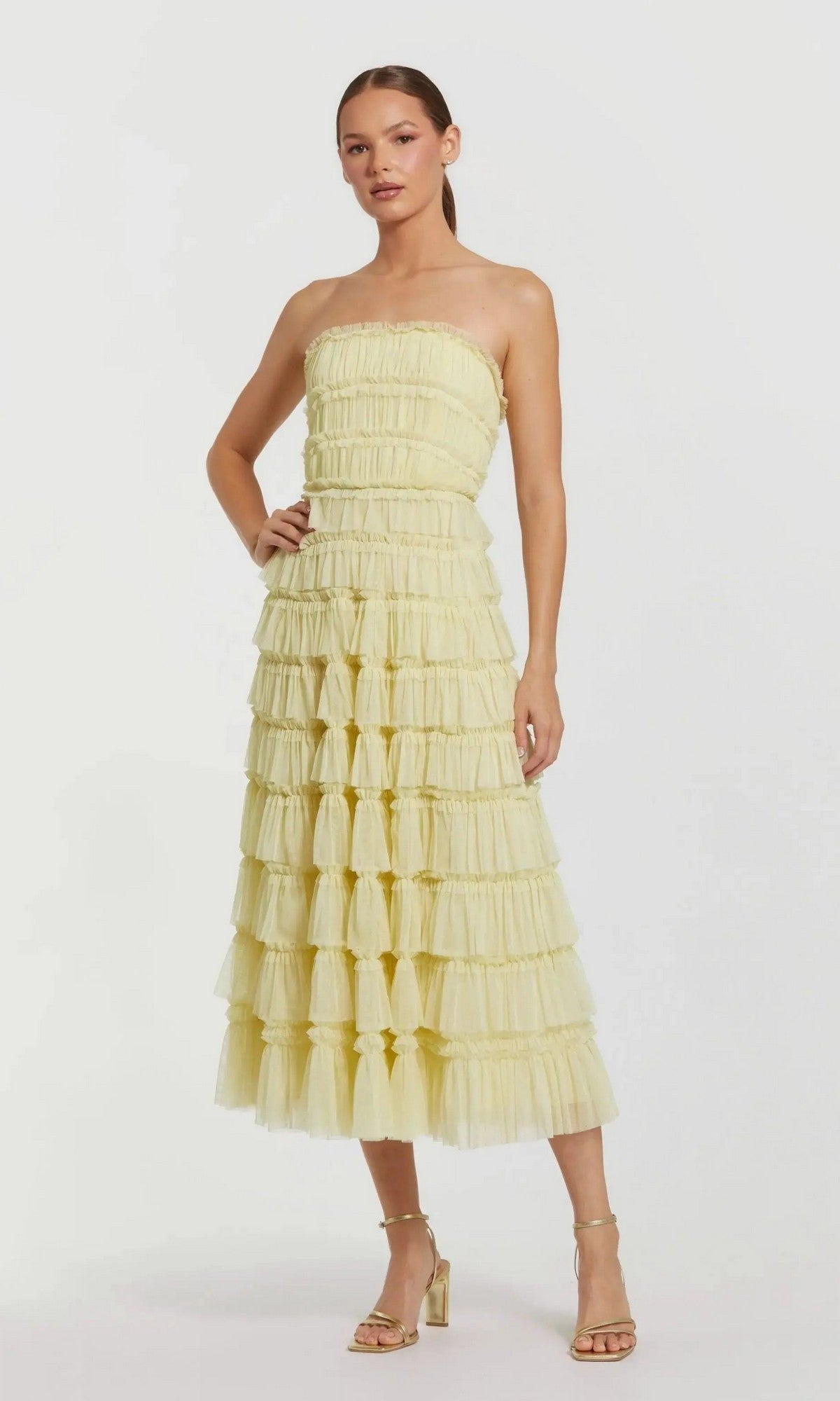 Woman wearing the Midi Semi-Formal Dress: Mac Duggal 8286 in buttercup, featuring a strapless design and micro-ruffle details, paired with heeled sandals and standing against a plain white background.